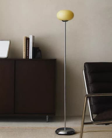 A contemporary floor lamp featuring a polished chrome base and stem, topped with a frosted yellow globe-shaped shade. — 3D model