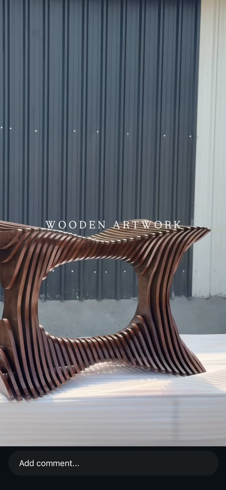 A modern sculptural bench constructed from numerous horizontal wooden slats, forming an undulating, hourglass-shaped profile with an open central void. — 3D model