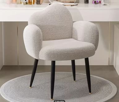 A contemporary accent chair featuring a sculptural form with an organically shaped backrest and integrated rounded armrests, upholstered in cream bouclé fabric. It is supported by four dark, splayed, tapered legs with brass caps. — 3D model