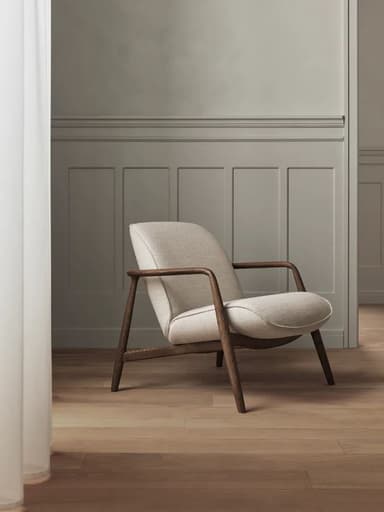 A contemporary lounge chair featuring a curved, off-white upholstered seat and backrest, supported by an exposed dark wood frame that forms the legs and armrests. The chair exhibits a minimalist design with clean lines and a comfortable aesthetic. — 3D model