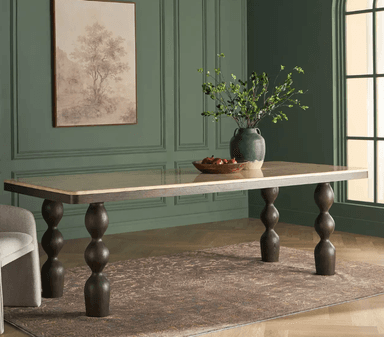 A rectangular dining table featuring a polished light-colored stone or composite top set within a dark stained wood frame. The table is supported by four distinctive sculptural legs, each crafted from dark wood with multiple stacked, turned spherical forms. — 3D model