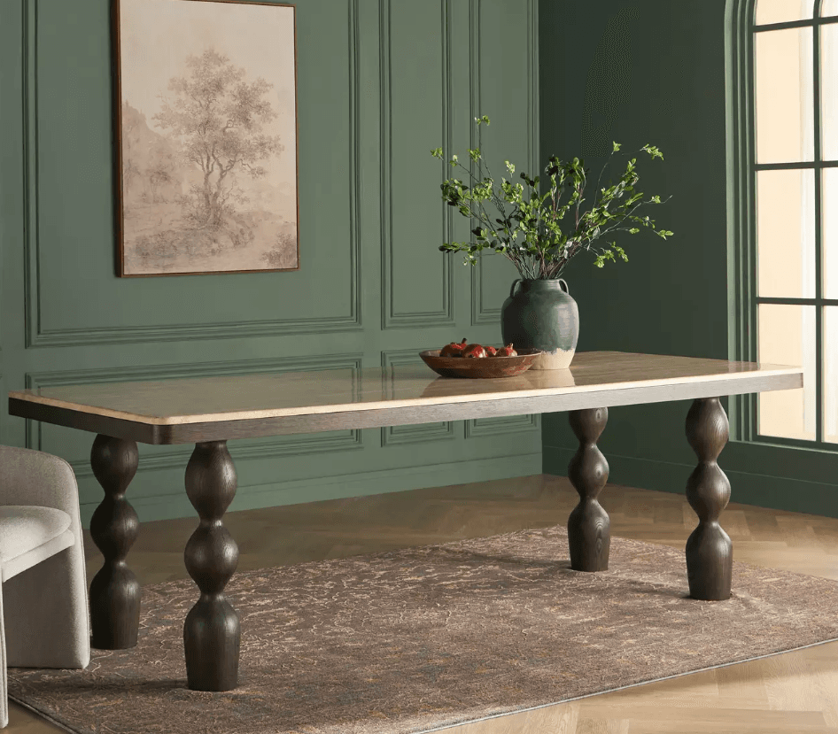 A rectangular dining table featuring a polished light-colored stone or composite top set within a dark stained wood frame. The table is supported by four distinctive sculptural legs, each crafted from dark wood with multiple stacked, turned spherical forms. — 3D model