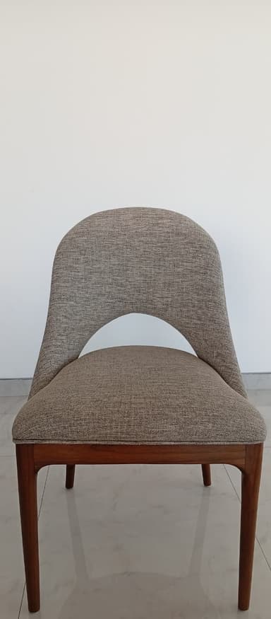A contemporary dining chair featuring a light gray upholstered seat and a distinctive curved backrest with a central cut-out, all supported by a dark stained wooden frame with four tapered legs. — 3D model