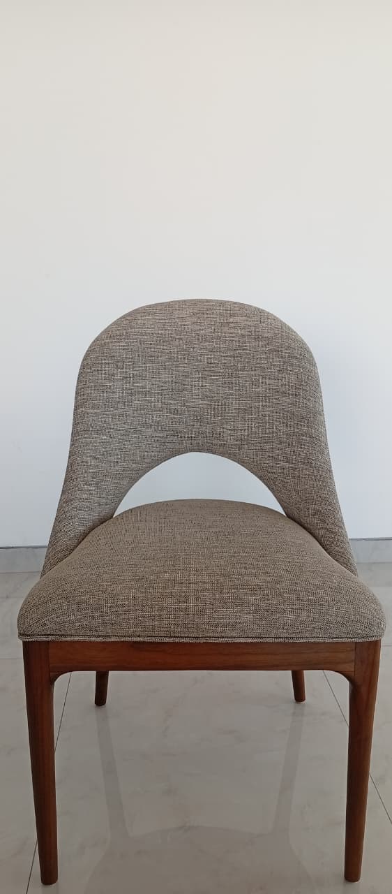 A contemporary dining chair featuring a light gray upholstered seat and a distinctive curved backrest with a central cut-out, all supported by a dark stained wooden frame with four tapered legs. — 3D model
