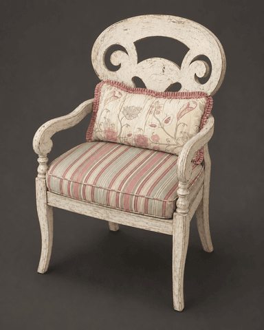 An off-white, distressed wooden armchair featuring a carved, ornate backrest with scroll motifs. It has a removable upholstered seat cushion with pink and green stripes, and a separate decorative back pillow with a floral and bird pattern. The chair's frame has gently curved armrests and legs, consistent with a French country or shabby chic aesthetic. — 3D model