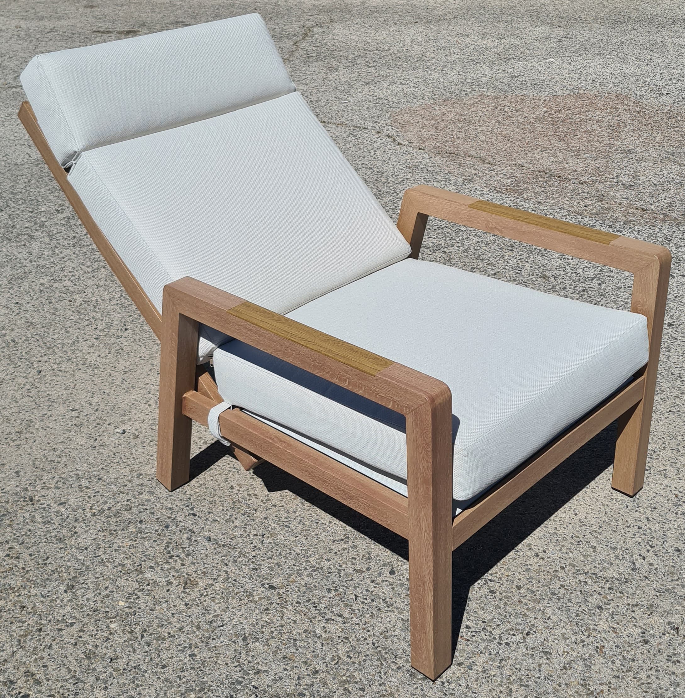 A lounge chair with a wooden frame and white upholstered cushions. The chair features adjustable backrest and armrests. The wooden frame has a natural finish, and the cushions are made of a textured fabric. Straps are visible to secure the cushions. — 3D model