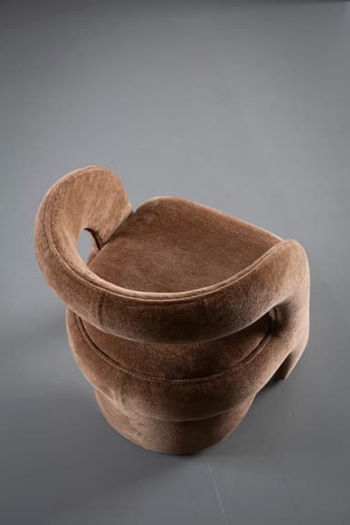 A contemporary sculptural accent chair fully upholstered in a textured medium brown fabric, featuring a continuous, curvilinear backrest and armrests that flow seamlessly into an integrated, upholstered cylindrical base. — 3D model