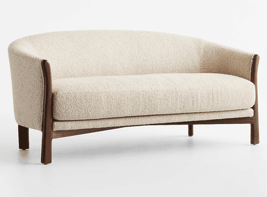 A two-seater loveseat featuring a curved back and integrated armrests, upholstered in a light-colored, textured boucle fabric. It is supported by a visible dark wood frame that extends from the base to form the armrests and partially the back structure. The loveseat rests on four short, solid wooden legs. — 3D model