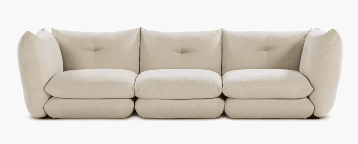 A three-seat sofa with a modular appearance, featuring deep, plush cushions and rounded arms. The back cushions are slightly tufted, and the overall design has a contemporary, comfortable aesthetic. The sofa sits low to the ground with a minimal base. — 3D model