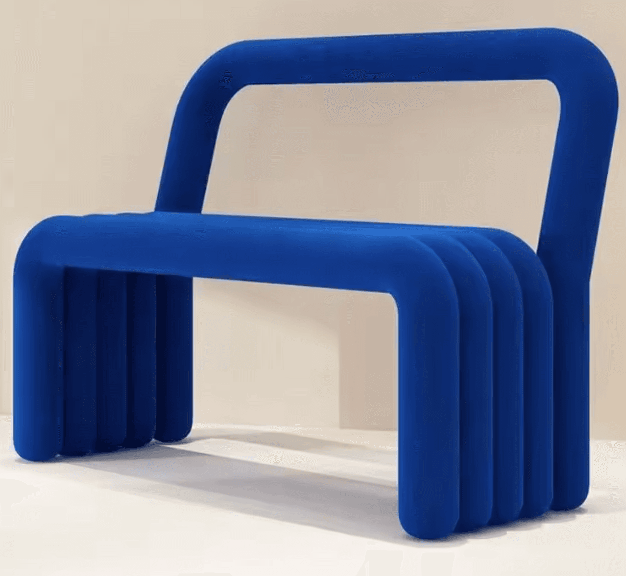 A vibrant blue armchair constructed from continuous, rounded tubular forms. The seat consists of three parallel tubular elements, while a single, larger tubular structure forms the backrest and integrated armrests, giving it a monolithic and sculptural appearance. — 3D model