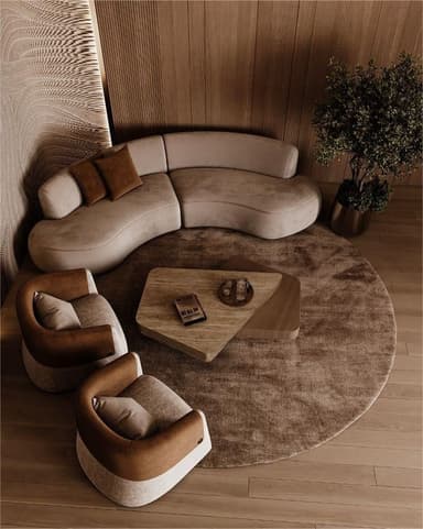 A curved, sectional sofa with a modern design. It features a soft, upholstered finish and appears to be modular, consisting of at least two connected sections. Two accent pillows in a contrasting darker shade are placed on one section. — 3D model
