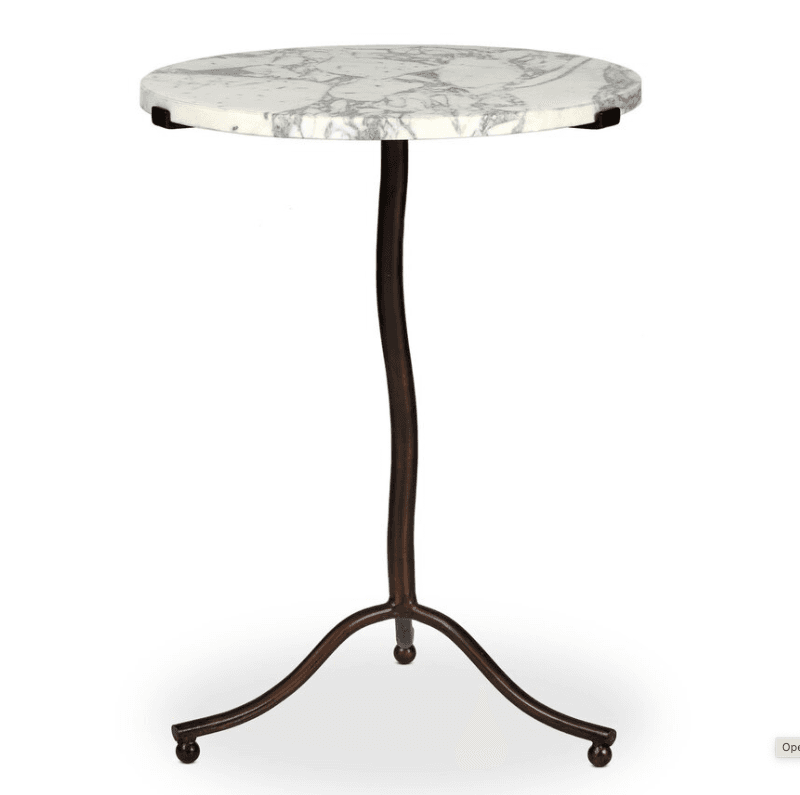 A small, round accent table featuring a white marble top with prominent grey veining, supported by a slender, curved dark metal (likely wrought iron) stem. The stem expands into a tripod base with decorative scrolled legs, each ending in a small, ball-shaped foot. — 3D model