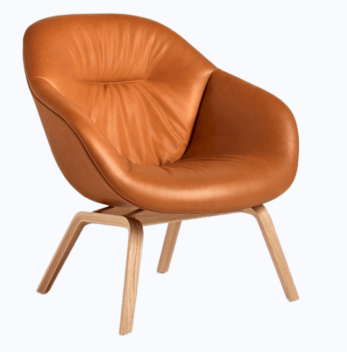 A modern lounge chair with a curved, upholstered seat and backrest supported by a wooden base. The seat appears to be made of tan-colored leather with subtle tufting. The base consists of four angled legs made from bent plywood, likely oak or a similar wood, finished in a natural tone. — 3D model