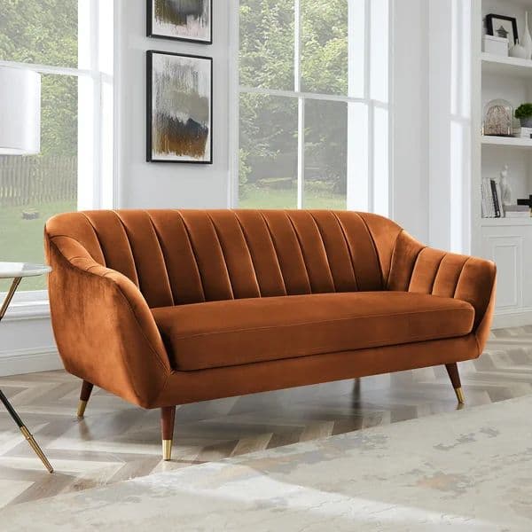 A terracotta orange loveseat featuring a distinct channel-tufted backrest and armrests, upholstered in velvet. The design includes a single, clean seat cushion and tapers down to four splayed wooden legs, each finished with a polished brass cap, indicating a mid-century modern aesthetic. — 3D model