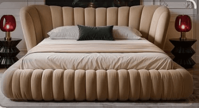 A contemporary low-profile daybed featuring plush, channel-tufted upholstery in a light beige or tan color. It presents a streamlined, minimalist form with a single integrated backrest on one side, also adorned with vertical channel tufting. The sleeping surface is flat and unadorned, suggesting a comfortable, minimalist design suitable for lounging or occasional sleeping. The base and sides are fully upholstered. — 3D model