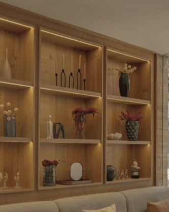 A modern, modular bookshelf unit featuring three vertical sections, each with multiple horizontal shelves. The unit is constructed from light-colored wood, possibly oak, with a smooth, natural finish. Integrated LED strip lighting is discreetly placed along the internal vertical dividers, illuminating each shelf compartment. The design is clean, minimalist, and functional, suitable for contemporary interiors. — 3D model