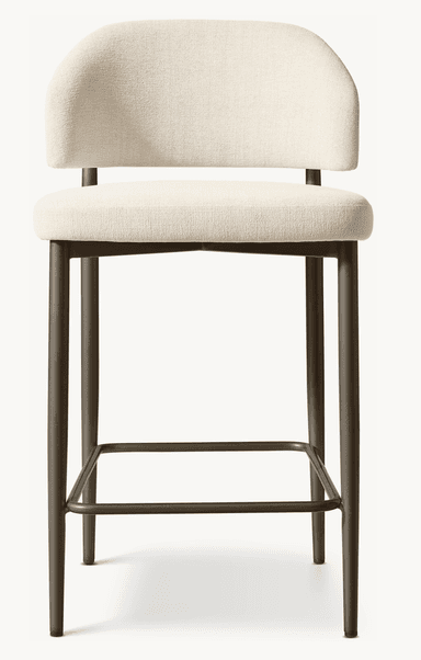 A contemporary bar stool featuring a light beige upholstered seat and a gently curved backrest, supported by a bronze-finished metal frame with an integrated square footrest. — 3D model