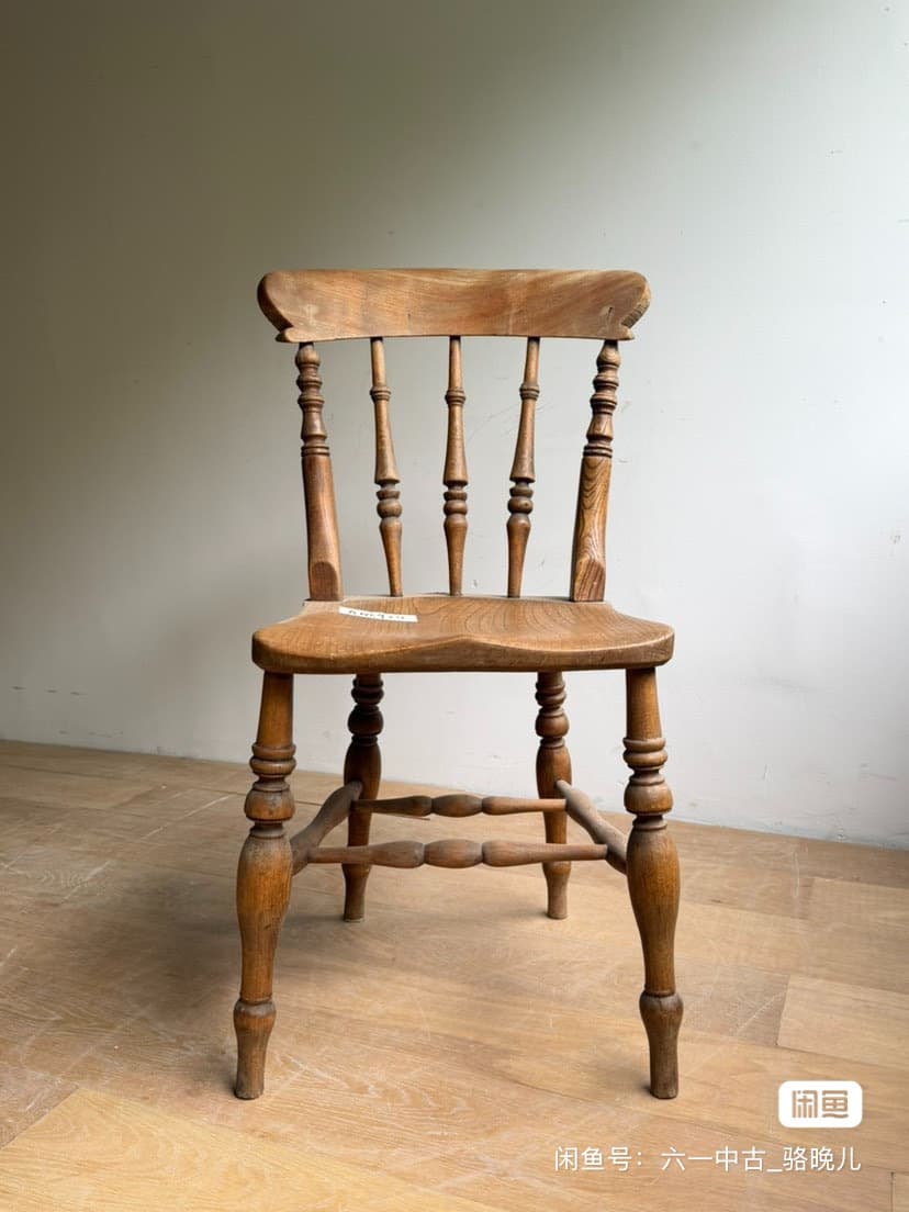 A vintage wooden side chair featuring a spindle back, turned legs, and a saddle-shaped seat, showcasing natural wood grain and signs of age. — 3D model
