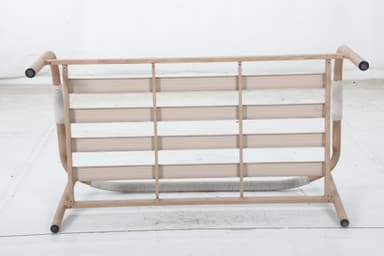 A two-seater sofa with a light-colored wooden frame and light-colored fabric upholstery. The frame features curved armrests and a simple rectangular base. The seat and back cushions are separate and appear to be filled with a soft material. — 3D model