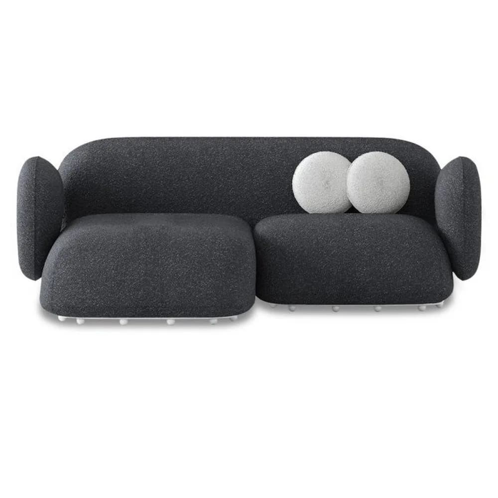 A contemporary two-seater sofa featuring soft, organic lines and a modular appearance. It is upholstered in a dark grey textured fabric, likely bouclé, and has distinct, rounded armrests that flow into the backrest. The sofa rests on small, spherical white feet. Two round white throw pillows are placed on one of the seat cushions. — 3D model