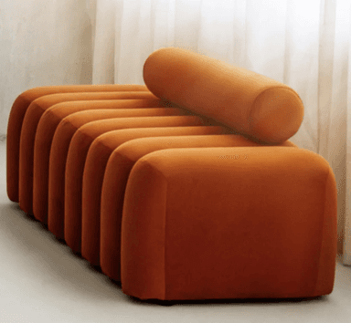 A modern bench with a rounded, segmented design. It features a base composed of multiple vertical, cylindrical cushions arranged in a row, topped by a single, long cylindrical cushion that runs horizontally across the top. The upholstery appears to be a soft, textured fabric. — 3D model