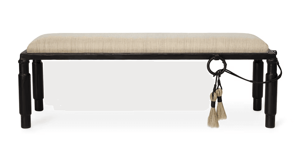 A rectangular bench with a cushioned seat and a dark-colored frame. The frame has four legs, and decorative elements including rings and tassels are attached to one side of the frame. — 3D model