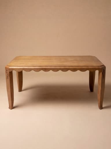 A rectangular dining table crafted from oak wood, featuring a distinctive scalloped apron and decorative carved embellishments on its corners. The table stands on four tapered legs with a subtle curve, reflecting an Art Deco or transitional design. — 3D model