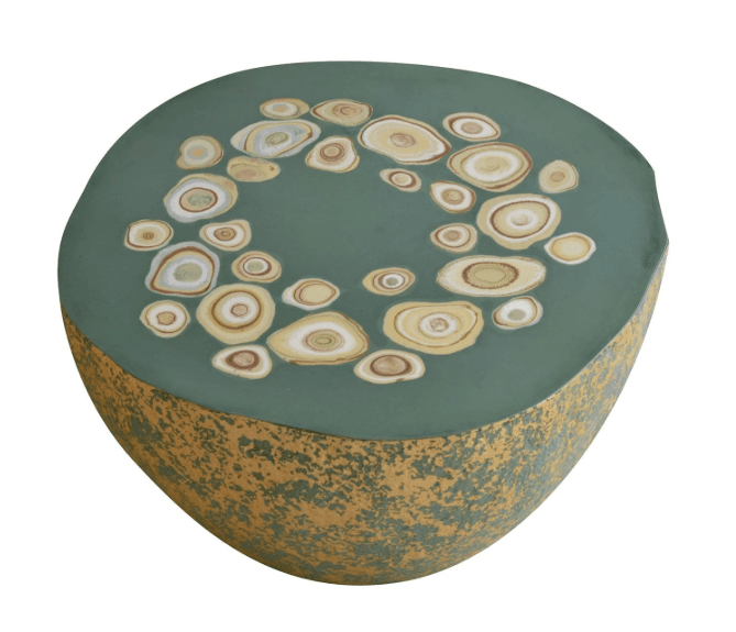 A low, round drum-shaped table with a flat green top featuring various abstract, agate-like circular inlays. The sides are textured with a distressed gold and green finish. — 3D model