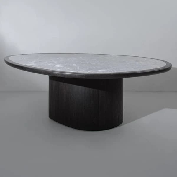 A contemporary coffee table featuring an irregular, organic-shaped light marble top supported by a substantial, dark-stained wood pedestal base. The design is minimalist and sculptural. — 3D model