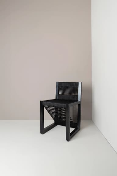 A contemporary chair with a black frame and a seat and backrest constructed from closely spaced black cords or ropes. The cords are stretched vertically across the frame, creating a textured and somewhat visually open surface. The legs are simple, straight, and square in profile. — 3D model