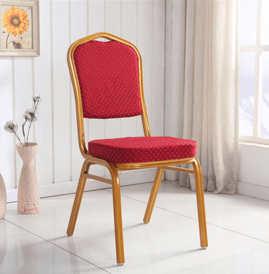 A classic banquet-style chair featuring a durable gold-finished metal frame and red upholstered seat and backrest. The upholstery has a subtle dotted pattern, and the chair's design suggests stackability for event use. The backrest has a rounded, arch-like top edge, and the legs are straight with plastic glides at the bottom. — 3D model