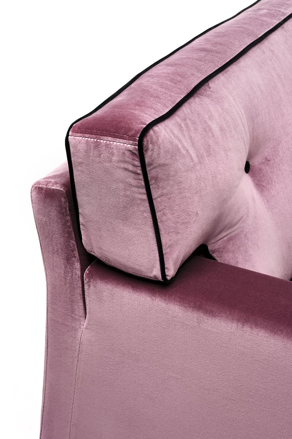 A close-up view of a sofa section, showcasing plush velvet upholstery in a dusty rose color. The sofa features a tufted back cushion with a black button accent and decorative black piping along the edges of the headrest and armrest. The material appears soft and textured, indicative of velvet. — 3D model