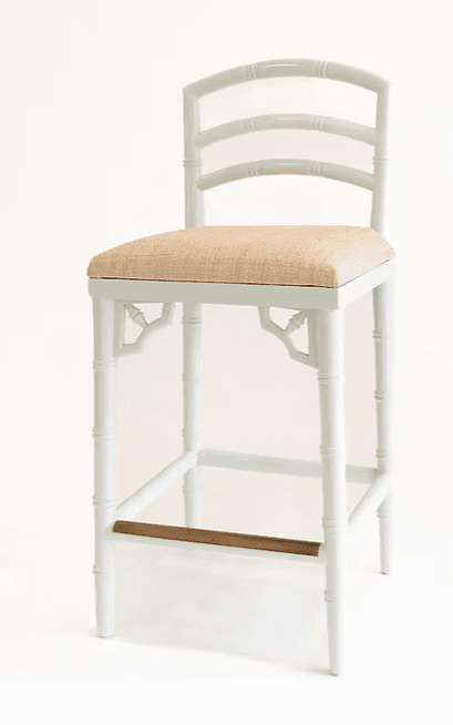 A light blue-grey painted counter stool featuring a bamboo-style frame. The stool has four legs, simulating bamboo stalks, with a metal footrest bar for support. The square seat is upholstered in a natural beige, woven textile. The backrest is a ladder-back style with three horizontal rungs, also in the bamboo motif. Decorative fretwork elements are present beneath the seat apron on all four sides. — 3D model