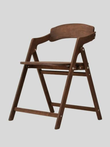 A dark brown wooden folding armchair, designed for compact storage and temporary seating. It features a simple, functional aesthetic with a curved backrest and integrated armrests. — 3D model