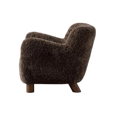 A barrel-shaped ottoman upholstered in dark brown, curly sheepskin or a high-pile faux sheepskin material, supported by four short, tapered wooden legs. — 3D model