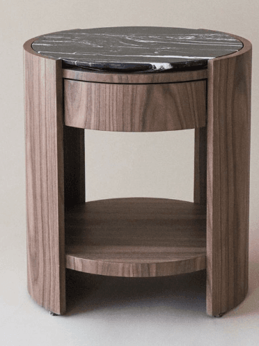 A modern round nightstand crafted from dark walnut wood with a polished black marble top. It features a single integrated drawer and an open circular lower shelf, supported by a curved panel design. The contrasting materials and clean lines give it a contemporary aesthetic. — 3D model