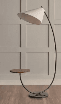 A contemporary floor lamp featuring a curved black metal frame, an integrated circular dark wood side table, and a white conical fabric shade. It is supported by a round, flat black base. — 3D model