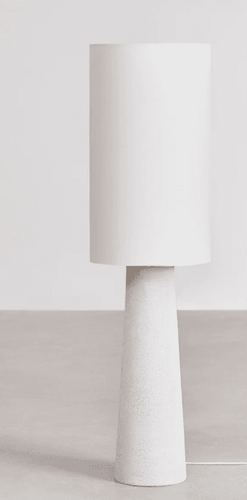 A modern table lamp with a cylindrical white lampshade and a tapered, textured white base. The base appears to be made of a material with a granular finish. — 3D model