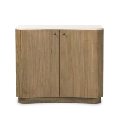A modern, two-door storage cabinet featuring a light-toned natural wood finish and a contrasting light-colored stone top. The cabinet has distinct rounded edges on its sides and a matching rounded, recessed plinth base, giving it a soft, contemporary silhouette. It includes two hinged cabinet doors, each fitted with a small, circular dark metal knob, suggesting internal storage. The wood grain is visible and consistent across the surfaces, indicating a solid wood or high-quality wood veneer construction. The overall appearance is minimalist and elegant. — 3D model