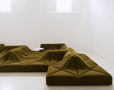 A large, olive green modular sectional sofa featuring a highly sculptural and geometric design with faceted, undulating surfaces that create an abstract, topographical landscape aesthetic. — 3D model