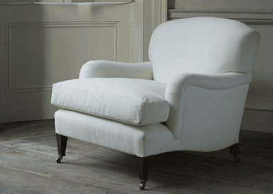 A deep green upholstered armchair with a curved back and rolled arms. It features a loose seat cushion and is supported by four wooden legs, with the front two legs equipped with brass casters. The upholstery appears to be a textured fabric. — 3D model