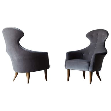 A mid-century modern inspired armchair with a high, sculpted backrest and tufted detailing. The chair features upholstered arms and is supported by four tapered wooden legs. — 3D model