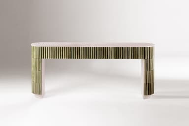 An elongated, narrow console table featuring a light pinkish-beige top and structural elements. The front and sides are extensively clad with vertical, muted green cylindrical elements, likely ceramic rods, creating a fluted or reeded texture. The base of the table follows the same pinkish-beige tone and features a subtle arched shape. — 3D model