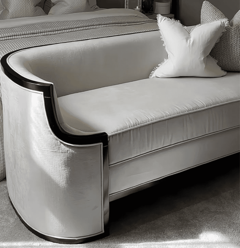 A sophisticated two-seater loveseat featuring a continuous, rounded back and integrated armrests, upholstered in a pristine white fabric. The entire silhouette is accentuated by a bold, black contrasting trim that outlines its elegant curves and base, giving it a distinctive Art Deco or contemporary aesthetic. — 3D model