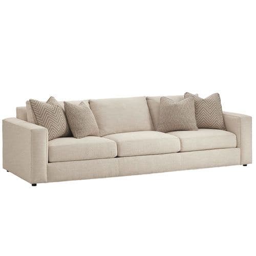A contemporary three-seater sofa with track arms, upholstered in a light beige, textured fabric. It features three loose seat cushions, three loose back cushions, and four accent throw pillows in complementary neutral tones and patterns. — 3D model