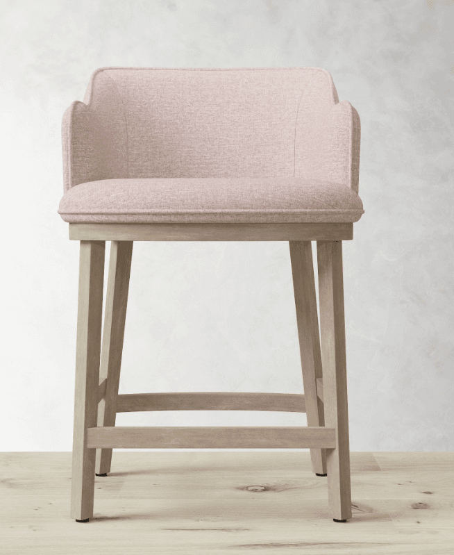 A upholstered bar stool with a light pink textured fabric seat and backrest, supported by a four-legged wooden base. The backrest has a scalloped design at the top and the arms are integrated into the backrest frame. The wooden legs are straight and connected by a lower stretcher bar for stability. The seat and backrest appear to be padded. — 3D model