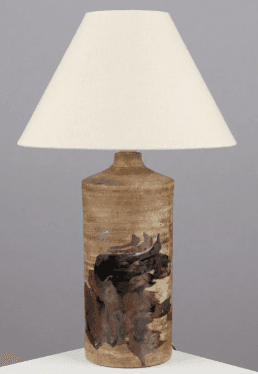 A table lamp featuring a cylindrical ceramic base with an abstract, earthy, and organic glazed pattern, topped with a plain conical fabric shade. The base exhibits varying shades of brown, black, and beige, creating a rustic and artistic aesthetic. A small metal neck connects the base to the shade. — 3D model