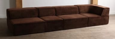 A contemporary modular L-shaped sectional sofa rendered against a white background. The sofa is composed of several individual square and rectangular units upholstered in a deep brown, textured fabric. It features a low profile with clean lines and minimal ornamentation, reflecting a minimalist design aesthetic. The arrangement consists of multiple armless segments and one corner segment, forming a continuous L-shape suitable for lounge seating. — 3D model