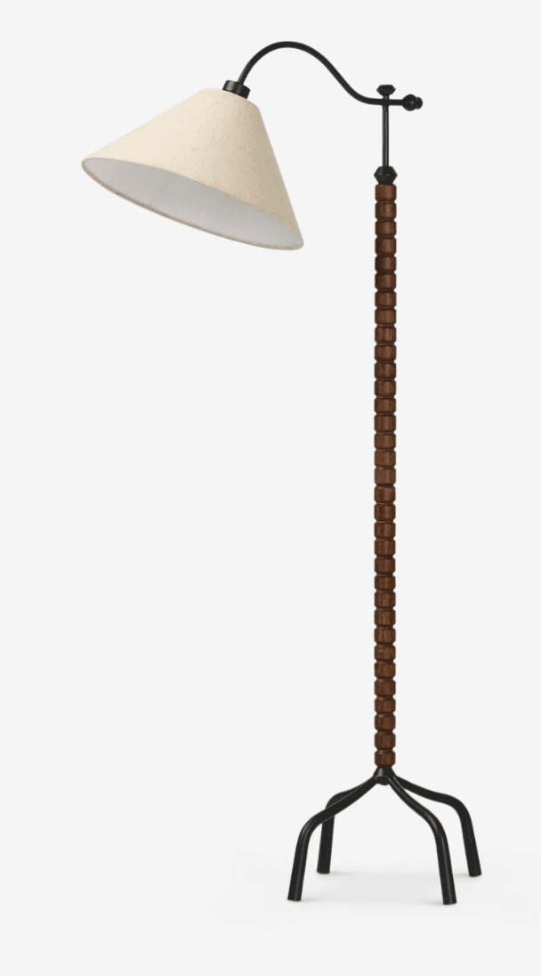 A contemporary floor lamp featuring a cream conical fabric shade suspended from a black metal gooseneck arm. The main stem is dark brown, meticulously wrapped with rectangular wood pieces, culminating in a robust black metal tripod base with splayed legs. The lamp combines natural textures with modern lines. — 3D model