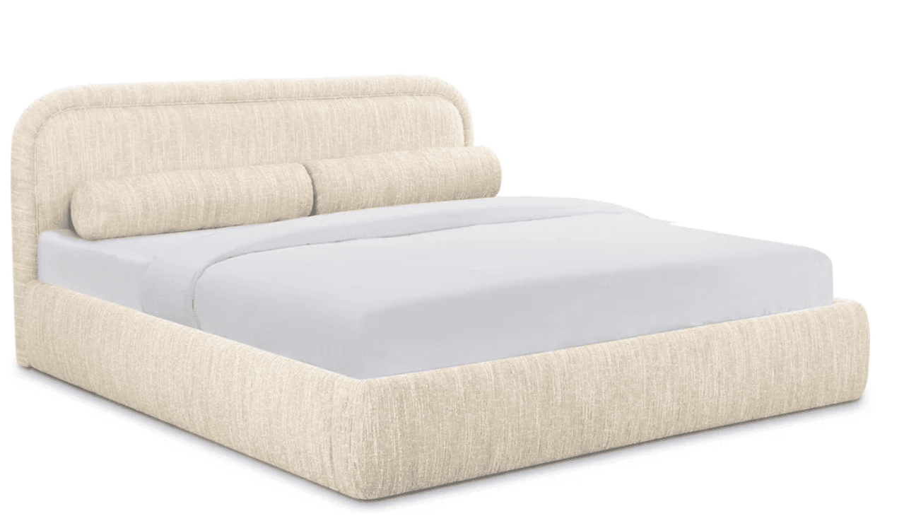 A contemporary, fully upholstered platform bed featuring a gently curved headboard and integrated cylindrical bolster pillows. The entire frame, including the headboard, footboard, and side rails, is covered in a textured, light cream or beige fabric. The low-profile design supports a mattress directly without the need for a box spring. — 3D model